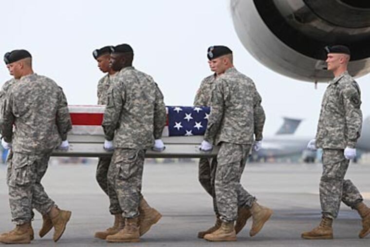 At Dover Air Force Base, the remains of Army Spec. Jamal Rhett, a medic killed in Iraq Sunday, are carried on their way back to his home and family in Palmyra. “He was my knight,” his mother said. (MICHAEL BRYANT / Staff Photographer)