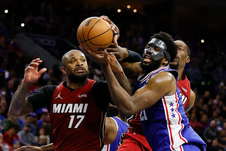 The Miami Heat's P.J. Tucker goes for a rebound with Sixers center Joel Embiid during their playoff series in May.