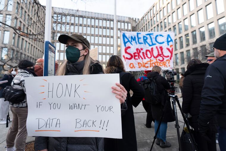 Protesters hold banners during a rally in front of the Office of Personnel Management in Washington on Monday, Feb. 3, 2025.