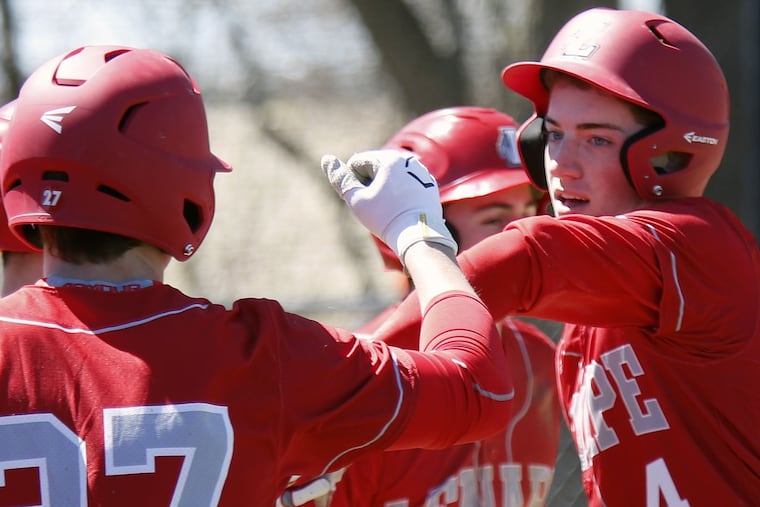 Lenape's Mike Doulong (4) bumps forearms with teammate Jake Topolski (27) after scoring a run against Cherokee during an Olympic Conference baseball game Saturday, April 8, 2017 at Cherokee. Lenape went on to win, 6-1. LOU RABITO / Staff