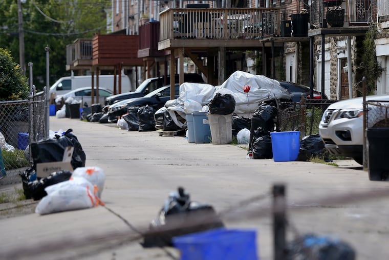 Bags of garbage sit along the street before being picked up in Philadelphia's Ogontz section earlier this month. Households are generating more trash as people stay home during the coronavirus pandemic.