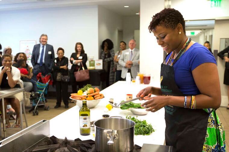 Dejenaba Gordon demonstrates her twist on traditional collard greens at the Free Library in Philadelphia's Culinary Literacy Center, part of a course on African heritage cooking and diet. ( LAURENCE KESTERSON / For The Inquirer )