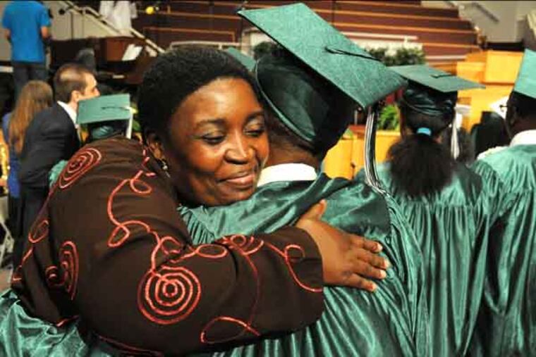 Sonya Kelly hugs her nephew Shyhiem Crump who is part of the class of 2013 of Germantown High School graduating June 19, 2013 at The Church of the New Covenant. The school is closing next school year so the class of 2013 is the last to graduate. ( CLEM MURRAY / Staff Photographer )
