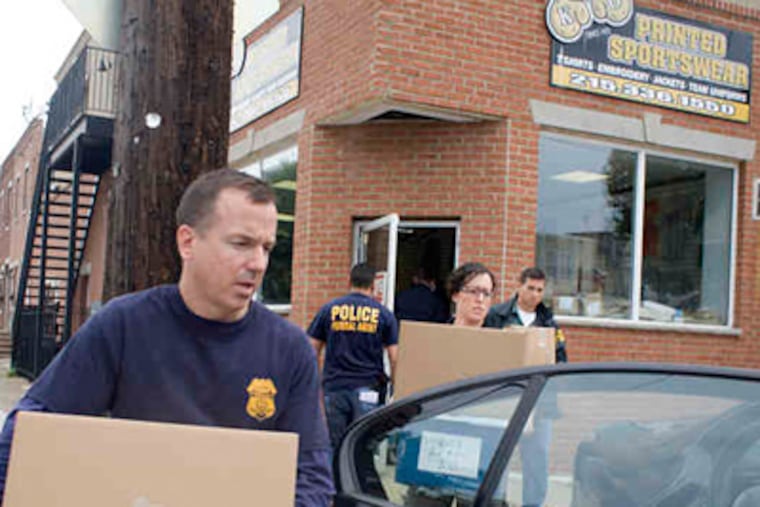 Federal agents remove material from KO Sporting Goods, also called KO Printed Sportswear, in South Philadelphia. (Ed Hille / Staff Photographer)