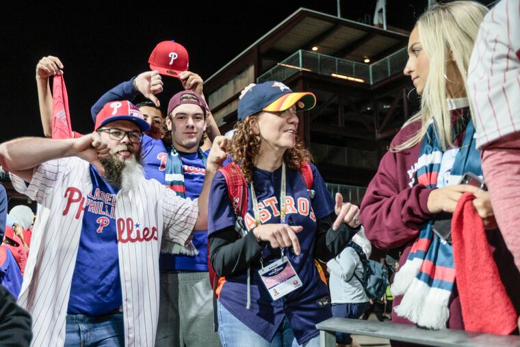 Justin Ellsworth from Seaford, Del., left and Gavin Carter of Drexel Hill center, react to Kristen Graham's Astros jersey at Game 3 of the World Series at Citizens Bank Park.
