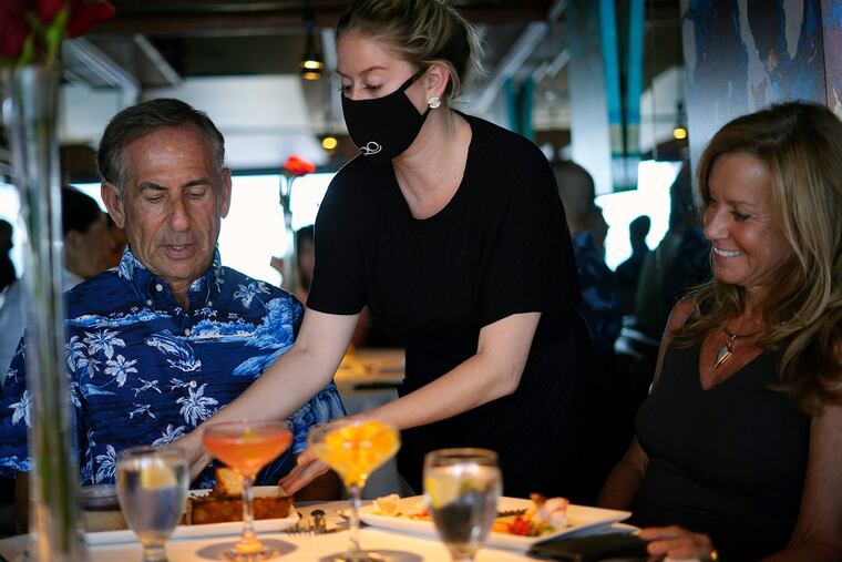 Irwin Scheineson, 65, and Denise Scheineson, 59, enjoy dinner and cocktails at the Beach Bistro in Anna Maria Island on Aug. 7, 2021. Bookings for restaurants are down more recently amid increased cases of the Omicron variant. (Luis Santana/Tampa Bay Times/TNS)