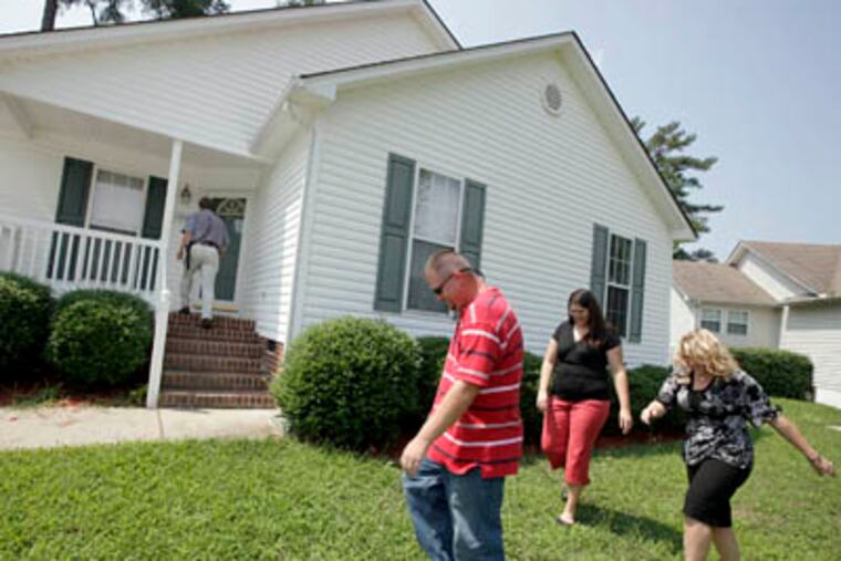 Jeremy and Shannon Wallace, center, first-time home buyers, do a walkthrough on an eleven-year-old house with a home inspector Bill Delamar, on porch in background, and their broker Kristal Eichar, far right, August 5, 2009, in the Emerald Pointe subdivision in Knightdale, North Carolina. (Shawn Rocco / Raleigh News & Observer / MCT)