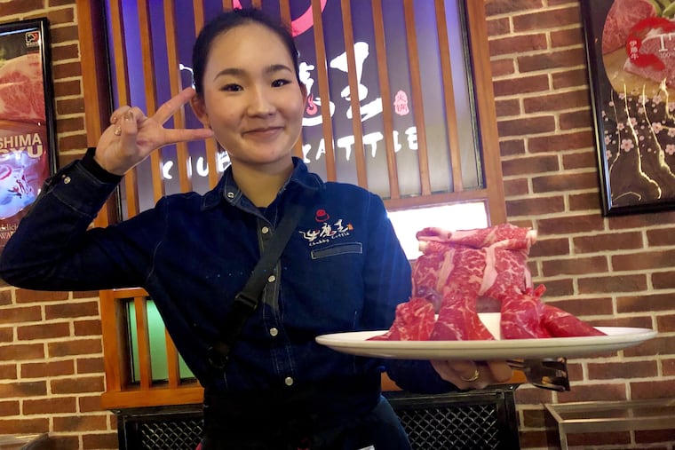 A server brings a platter of Wagyu beef for the hot pot at Chubby Cattle in Chinatown.