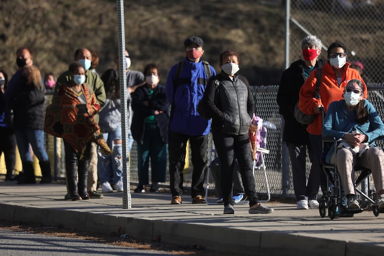 People with appointments wait in line to receive the COVID-19 vaccine at a walk-up public health vaccination site on Jan. 26, 2021, in Los Angeles.