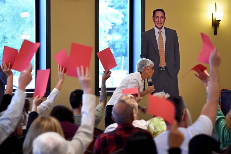 A cardboard cutout of U.S. Rep. Frank LoBiondo stands in for him at town hall for his constituents in Egg Harbor City May 31, 2017. At the microphone is Tamar Sherer, of Long Beach Township, who organized the meeting.