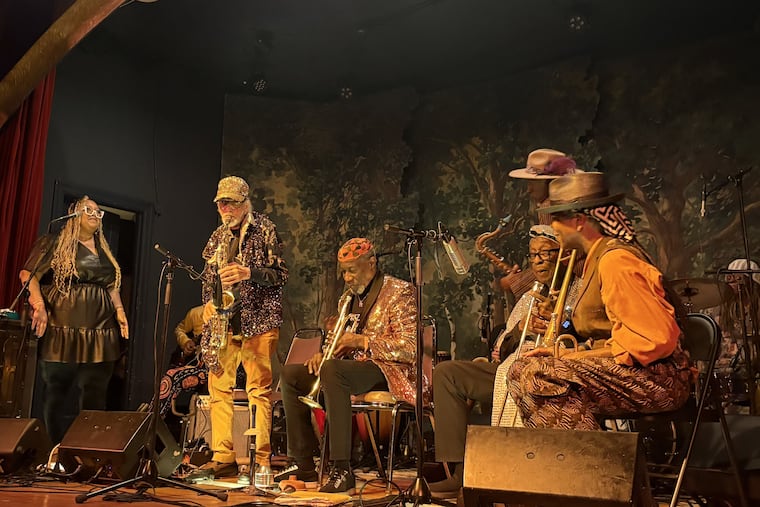 Marshall Allen (standing, with saxophone) with Tara Middleton to his right and Michael Ray to his left at the Sun Ra Arkestra leader's 102nd birthday celebration at the Ruba Club in Northern Liberties in Philadelphia on Sunday May 24, 2026.
