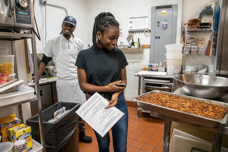 Christine Thompson, 16, looks at the Jamaican-style bread pudding baked and unveiled by chef Damon Menapace (not pictured) in the kitchen of Le Virtu restaurant in South Philadelphia on Thursday, March 14, 2019. Thompson's parents are currently seeking sanctuary in the First United Methodist Church of Germantown. All proceeds from the bread pudding at the restaurant will go to the Thompson family.