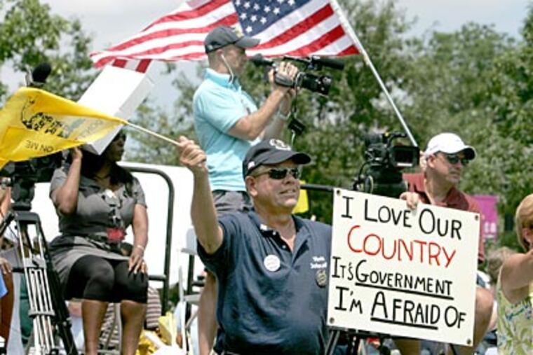 Wayne Laraway of Long Valley, NJ (center) waves a flag as hip-hop artist Jericho Saliz performs during the Tea Party's "Uni-Tea" on Independence Mall. (Charles Fox / Staff Photographer)