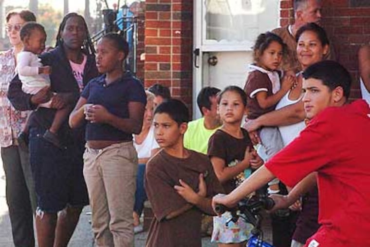 A crowd gathers in Port Richmond at the scene of a shooting that injured a woman and her infant granddaughter. (Jessica Westergom / Staff Photographer)