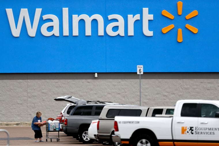 In this March 31, 2020 file photo, a woman pulls groceries from a cart to her vehicle outside of a Walmart store in Pearl, Miss. For $98 a year, Walmart+ customers get unlimited deliveries of purchases of at least $35. (AP Photo/Julio Cortez, File)