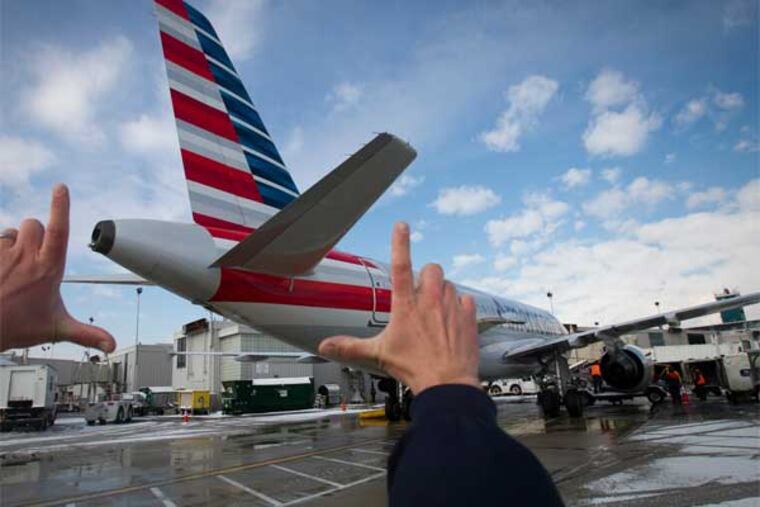John Golembiewski, fleet manager with US Airways frames the newly painted tail of and Airbus A319. American Airlines flight 1770 from Atlanta arrived at Philadelphia International Airport wearing the new paint job on Wednesday morning Feb. 26, 2014. This Airbus A319 was serviced at the US Airways terminal. (Alejandro A. Alvarez / Staff Photographer)
