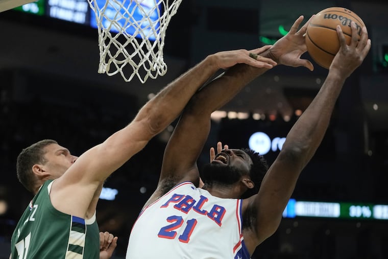 Brook Lopez of the Bucks fouls Joel Embiid.