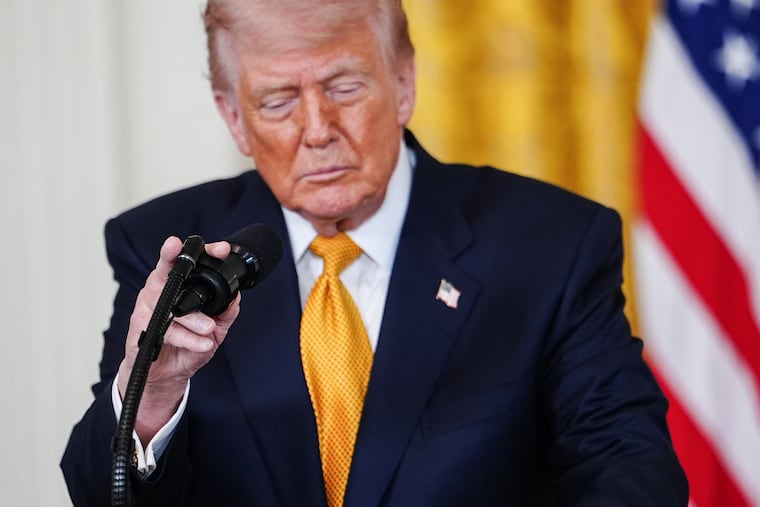 President Donald Trump adjusts his microphone while speaking during an event for military mothers in the East Room of the White House on Wednesday.