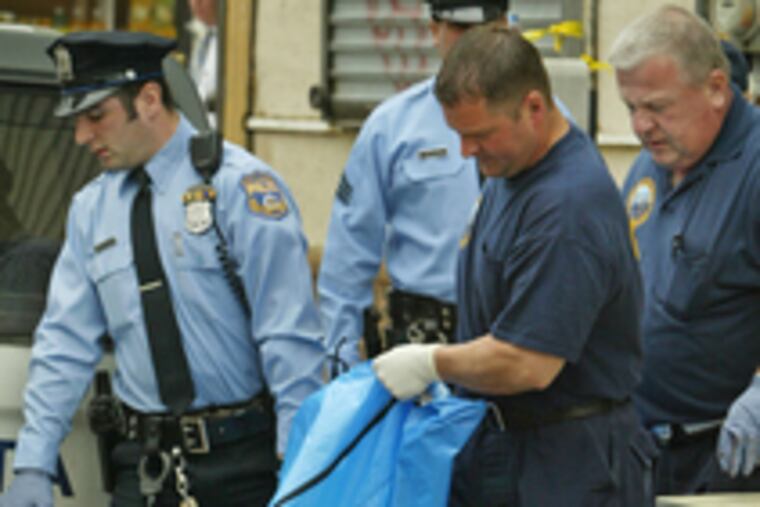 Police yesterday remove body of one of two women stabbed to death in South Philly apartment.