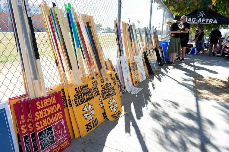 Striking SAG-AFTRA members pick out signs for a picket line outside Netflix studios on Wednesday.