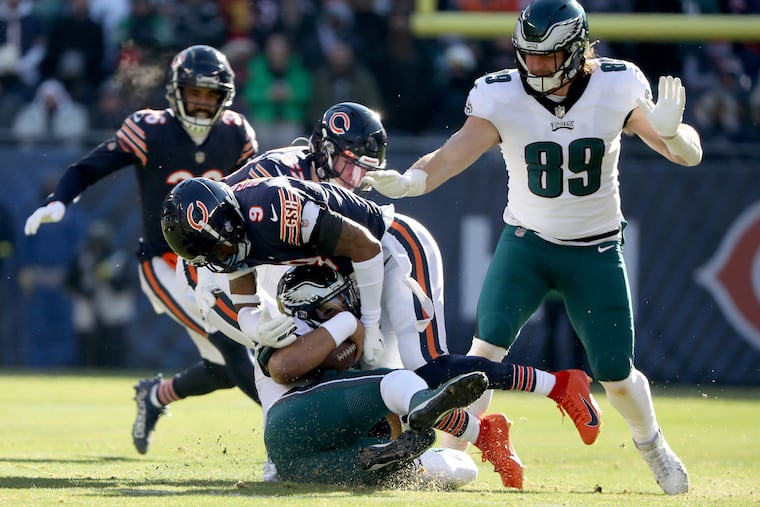 Eagles quarterback Jalen Hurts slides as he is tackled by Chicago Bears safety Jaquan Brisker.