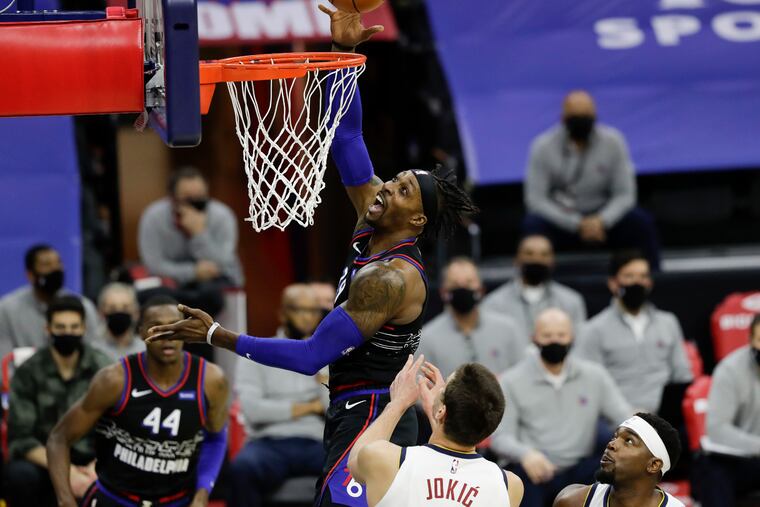 Sixers center Dwight Howard gets fouled going to the basket against Nuggets center Nikola Jokic on Saturday. Howard finished with 11 points and 11 rebounds.