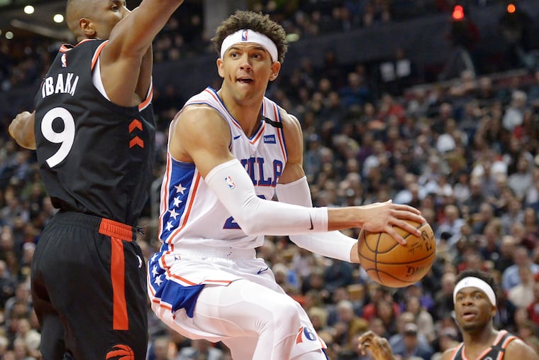 76ers guard Matisse Thybulle passes the ball around Toronto Raptors forward Serge Ibaka during the second half.