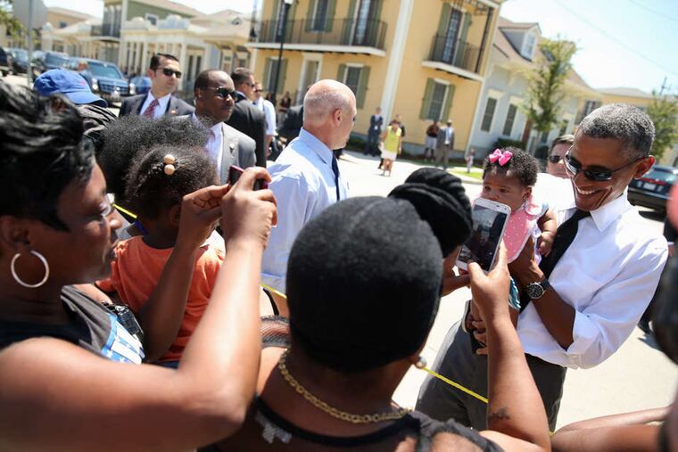 President Obama greets residents of the Treme section of New Orleans while visiting the city with Mayor Mitch Landrieu (center) 10 years after Hurricane Katrina devastated the area. Obama praised the progress but also noted much hard work remains. Story, A6.