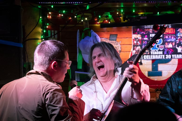 Philadelphia music legend Kenn Kweder, right, whose career dates back to the 1970’s at every imaginable club around town., reacts as an audience member takes the microphone. On May 10, 2022, he played his 1500th consecutive Tuesday night at Smokey Joe's in West Philly, dating back to 1992.