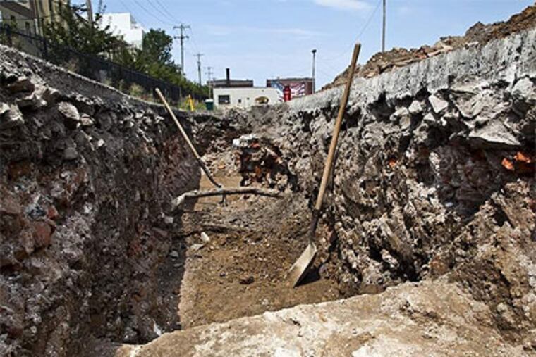 A large trench dug in a parking lot at Columbus Boulevard and Vine Street shows walls believed to be from the 19th-century West Shipyard. (Elise Wrabetz / Staff Photographer)