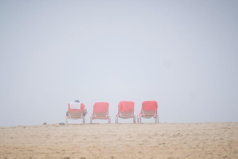 A man rests on a beach chair during a rainy and foggy Memorial Day in Cape May.