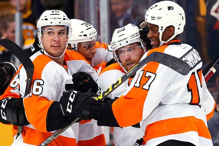 Philadelphia Flyers center Claude Giroux (28) (second from right) is congratulated by center Chris VandeVelde (76), right wing Pierre-Edouard Bellemare (78) and right wing Wayne Simmonds (17) after his game winning goal during overtime of the Philadelphia Flyers 5-4 win over the Boston Bruins at TD Garden.