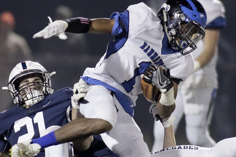 Hammonton’s Dayquan Murray getting stopped by Shawnee’s Jon Searcy in the first half of the South Jersey Group 4 championship football game at Rowan University in December.