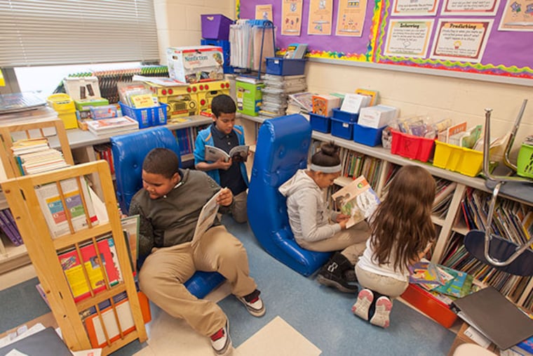 Fourth grade students in Elizabeth Rodriguez's class at Catto Community school in Camden look over books in the the reading area Rodriguez would enhance if she were to receive funding from DonorsChoose on Feb. 5, 2014. ( RON TARVER / Staff Photographer )