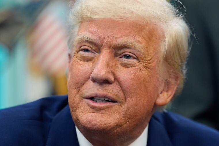 President Donald Trump speaks with reporters as he signs an executive order in the Oval Office of the White House on Friday.