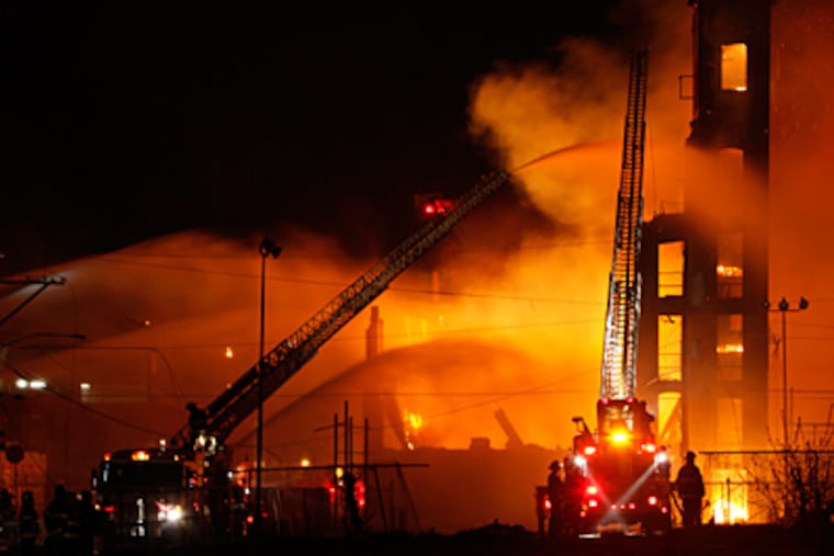 Firefighters battle a five-alarm fire in a warehouse on York Street
near Kensington Avenue in the Kensington section of Philadelphia on
Monday April 9, 2012. (Joseph Kaczmarek)