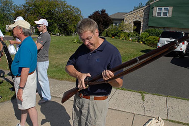Jim Johnston, a member of the 69th Pennsylvania Regiment, checks out a rifle before he and his group head to a Civil War reenactment in Virginia. (Ron Tarver / Staff Photographer)