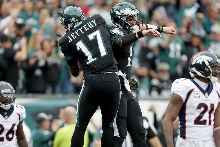 Eagles’ Carson Wentz (right) celebrates with Alshon Jeffery after they connected on a touchdown against the Broncos.