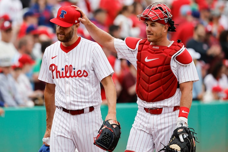 Phillies catcher J.T. Realmuto jokes with pitcher Zack Wheeler before Friday's spring training game against the Tigers at BayCare Ballpark in Clearwater Fla.