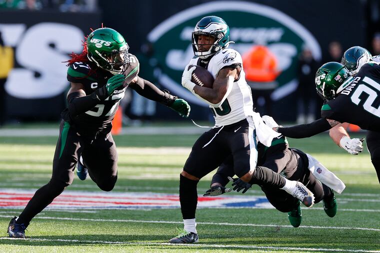 Miles Sanders runs with the football during the first quarter against the New York Jets as linebacker C.J. Mosley (left) moves in.