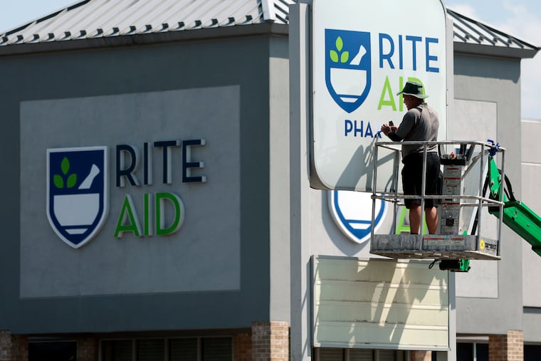 Efren Romero and Beltway Commercial Services have been tasked with removing the word “pharmacy” from approximately 50 Rite Aid locations. Romero was working at a Rite Aid store Tuesday, in Sewell, N.J.