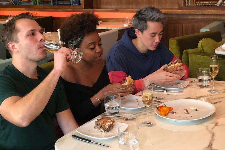 Andrew Ilnyckyj (left), Philly comedian Quinta Brunson, and Steven Lim taping an episode of the BuzzFeed series "Worth It" at Barclay Prime steakhouse.