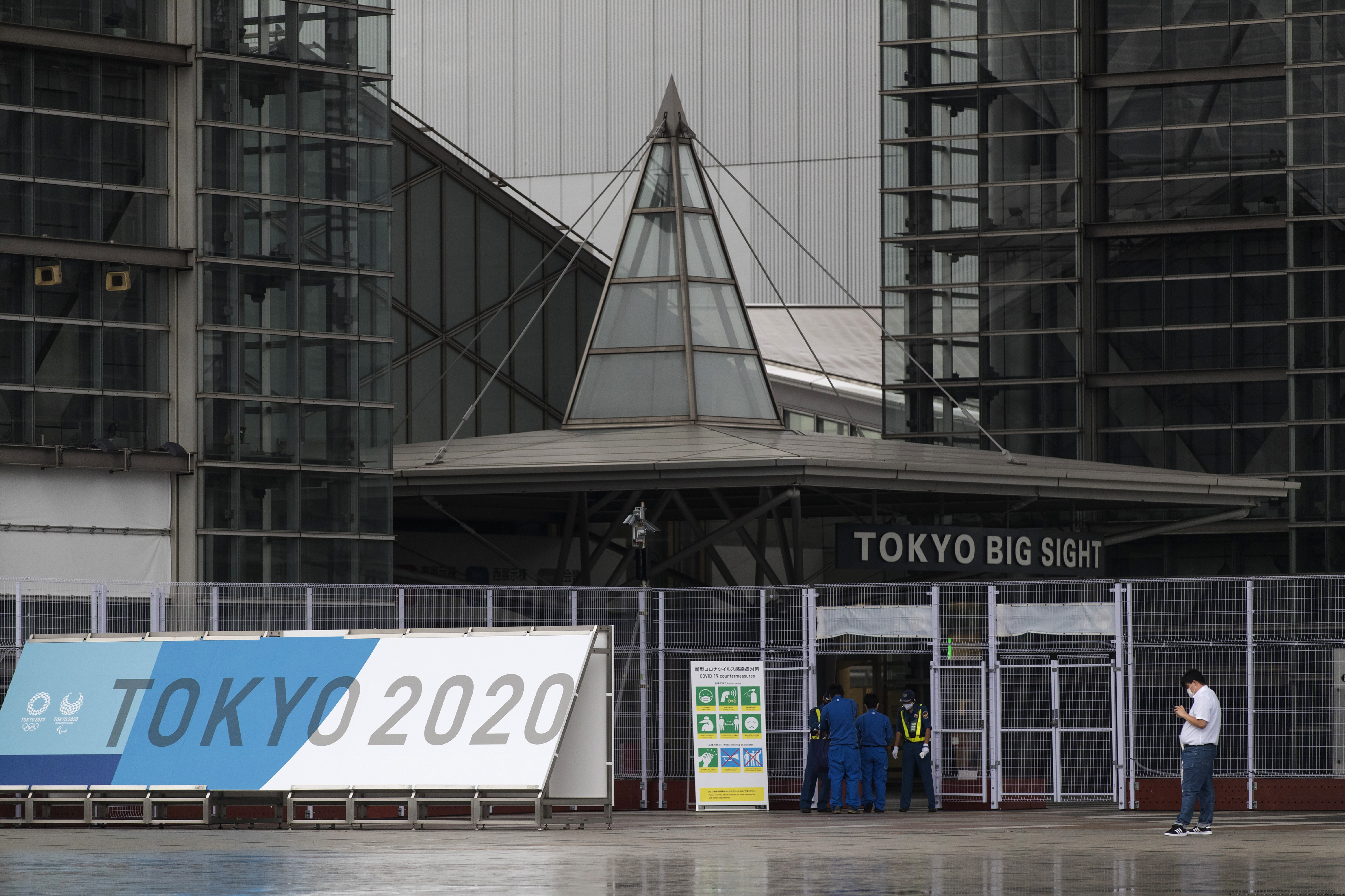 Security guards check ID cards and temperatures of workers as they enter a convention center housing the main media center of the Olympic and Paralympic Games in Tokyo on Friday.