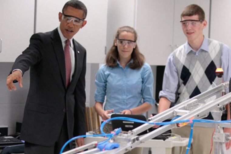 President Obama with Virginia students Meghan Clark and Nathan Hughes, who demonstrated their robotic device. "I don’t want a robot to run over me," Obama said. (Pablo Martinez Monsivais / Associated Press)