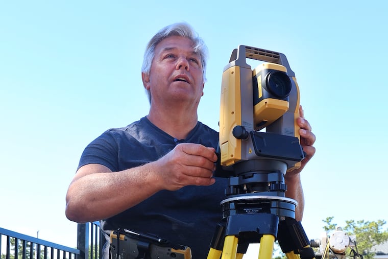 Former physics high school teacher James Huebner takes an angular measurement with his Theodolite as he works on a surveying job in the Long Beach Island community of Loveladies, N.J. on June 23, 2021 Photo: Tom Briglia