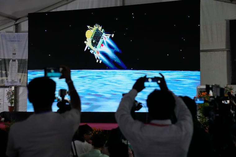 Journalists film the live telecast of spacecraft Chandrayaan-3 landing on the moon at ISRO's Telemetry, Tracking and Command Network facility in Bengaluru, India, on Wednesday.