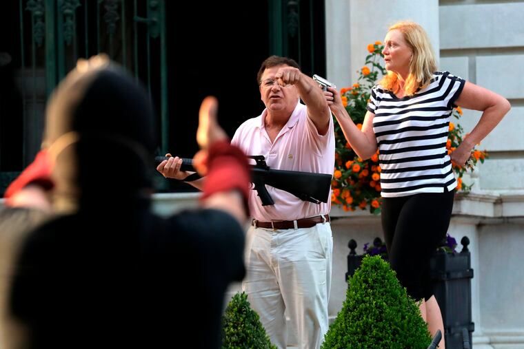 Armed homeowners standing in front their house along Portland Place confront protesters marching to St. Louis Mayor Lyda Krewson's house.