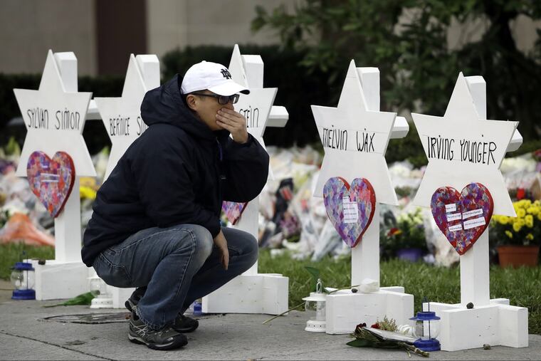 A person pauses in front of Stars of David with the names of those killed in a deadly shooting at the Tree of Life Synagogue, in Pittsburgh, Monday, Oct. 29, 2018.