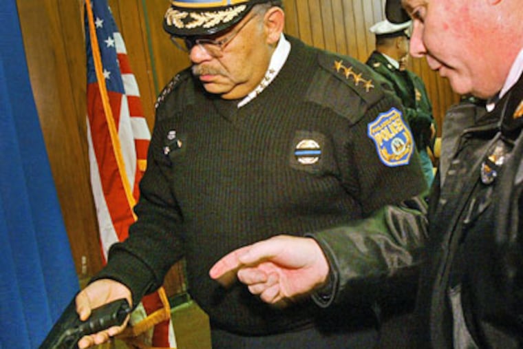 Philadelphia Police Commissioner Charles Ramsey, (left) handles a Glock semi-automatic pistol during a press conference Friday. (Alejandro A. Alvarez / Staff Photographer)