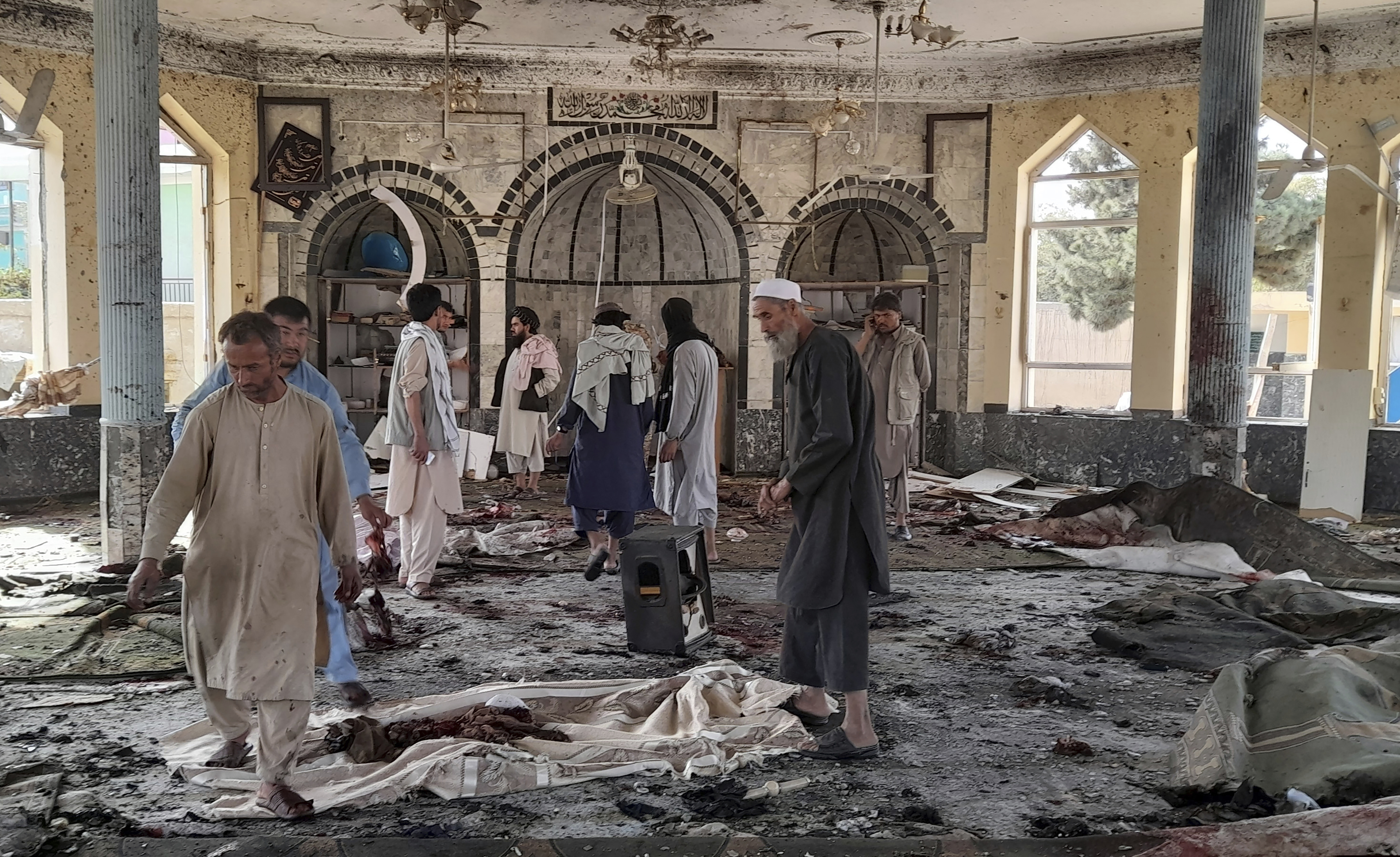 People view the damage inside of a mosque following a bombing in Kunduz province in northern Afghanistan.